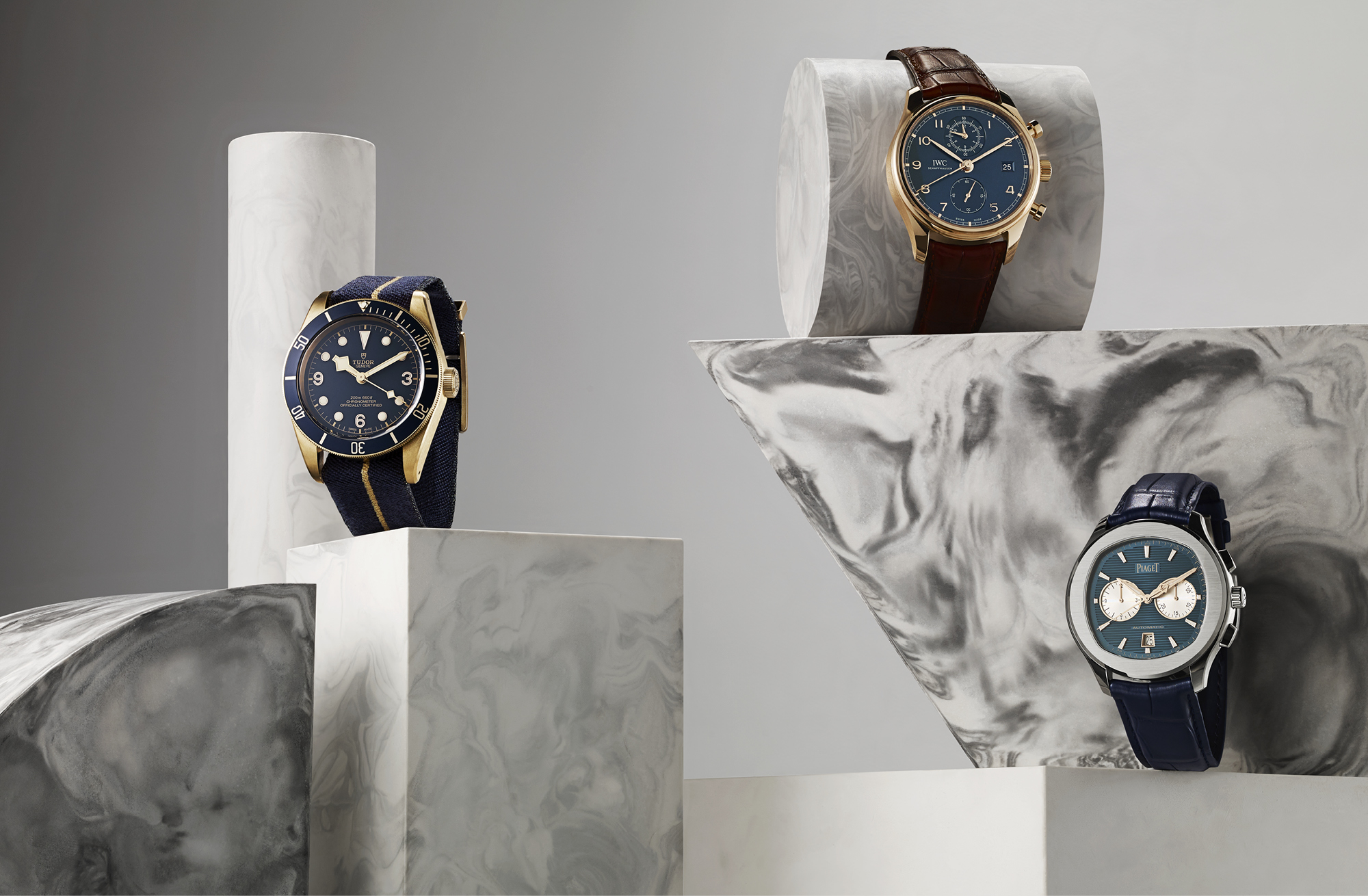 Bucherer Blue Editions - From left: Black Bay Bronze Blue 43mm, £2,860, TUDOR; Portugieser 42mm rose gold round dial automatic, £17,950, IWC; Polo S 42mm stainless steel cushion dial automatic, £11,400, PIAGET