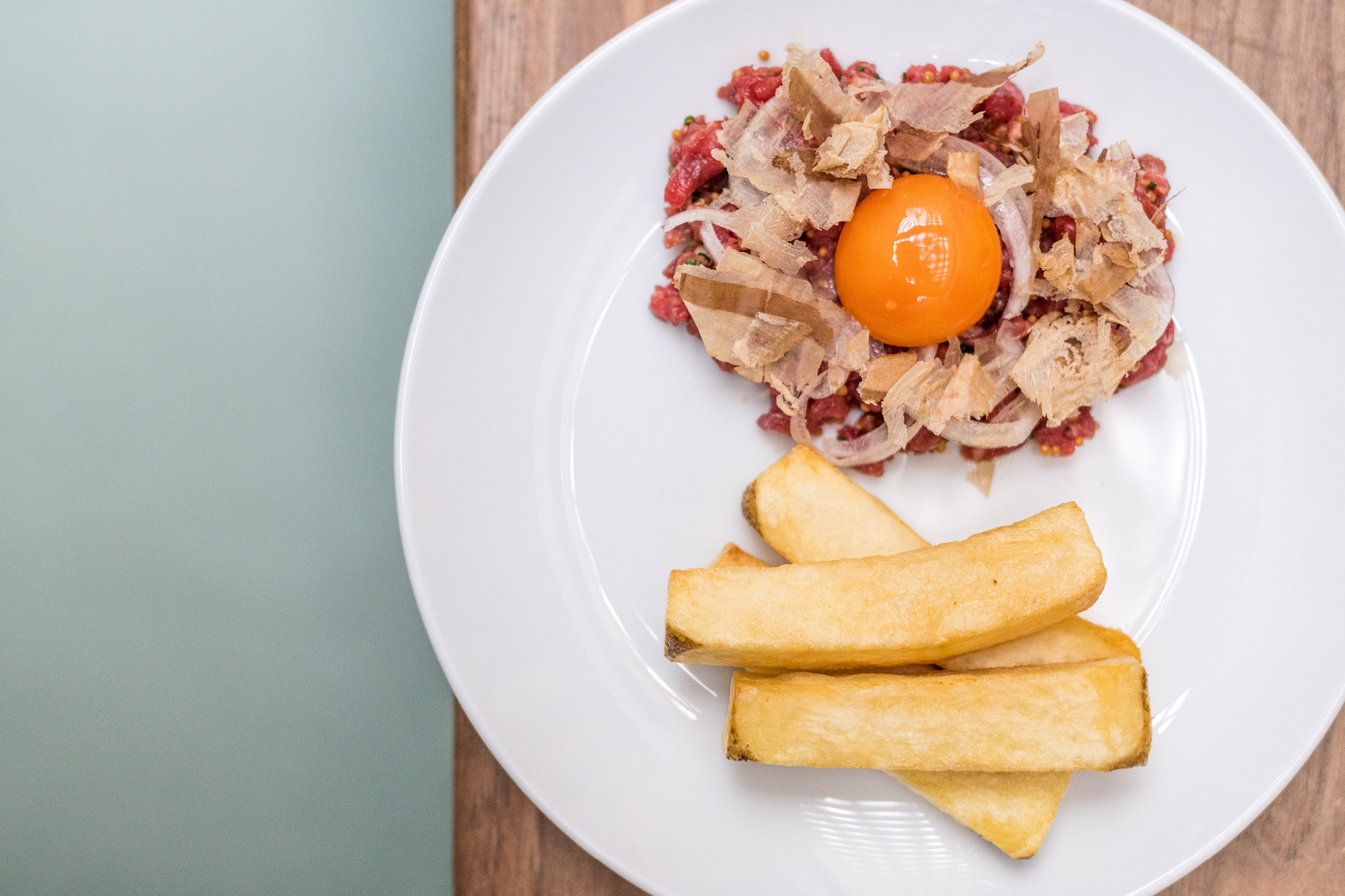 Hereford beef tartar, fermented chilli, prawn oil, egg yolk, bonito, triple-cooked beef fat potato chips at The Laundry