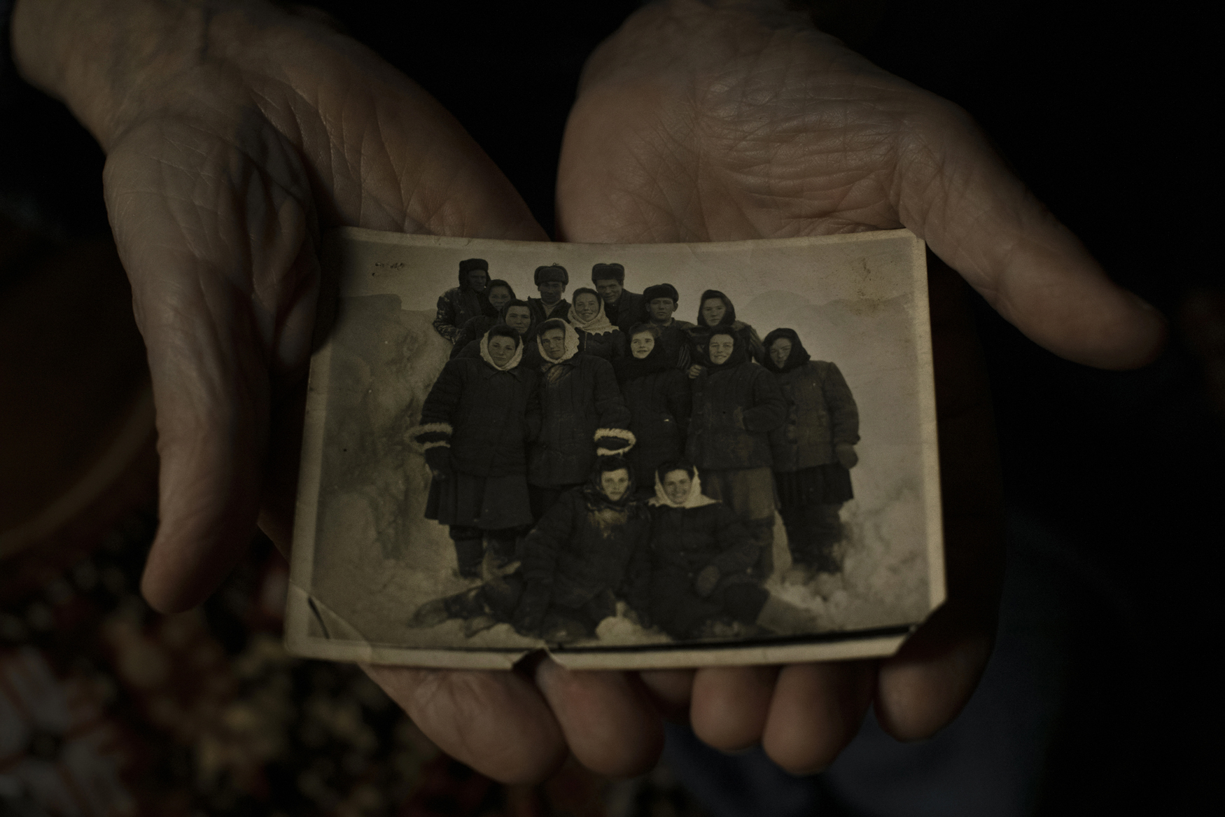 Magadan, Russia - November 29, 2019. [Portrait] A photograph of Antonina Novosad’s work brigade, taken in one of Kolyma's forced labour camps. Born in 1927 in western Ukraine, Novosad was sentenced to 10 years on fabricated political charges and was released in 1956 after serving nine years. Kolyma Region, Russia - November 17, 2019. Remnants of barracks of the Butugychag forced labour camp. There, after the Second World War, prisoners of Stalin’s gulags mined uranium that was used in the Soviet nuclear weapons program. MAGADAN, Russia - 30 October, 2019. Descendants of victims of political repression commemorate those who died in the Soviet forced labour camps of the Kolyma region. At the 'Mask of Sorrow' monument, which stands above the city of Magadan, they are joined by officials and service members. © Emile Ducke Kolyma, Along the Road of Bones