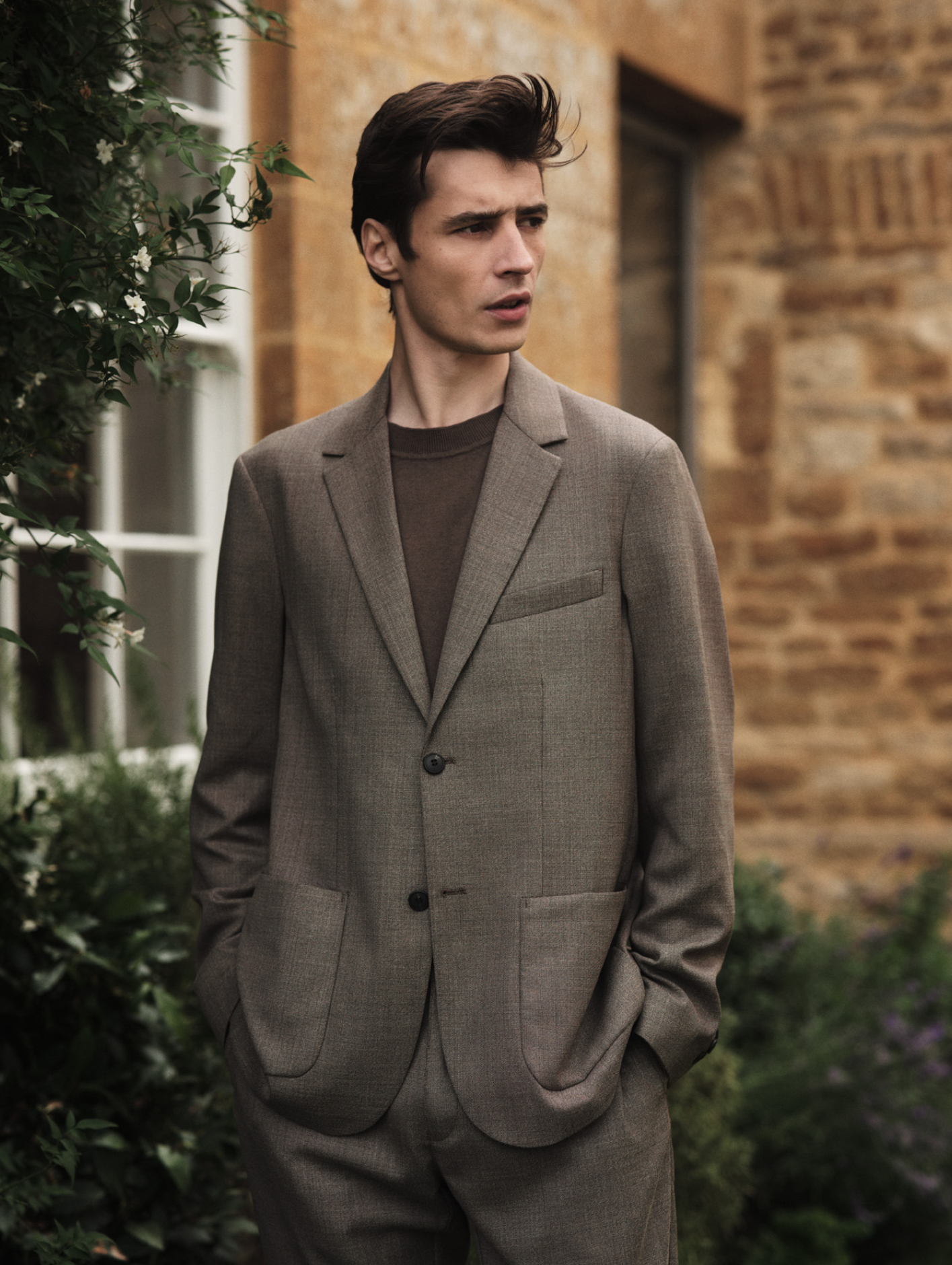 Travel Wool two-piece suit in dark stone melange, £950; Sea Island cashmere crew neck jumper, £325