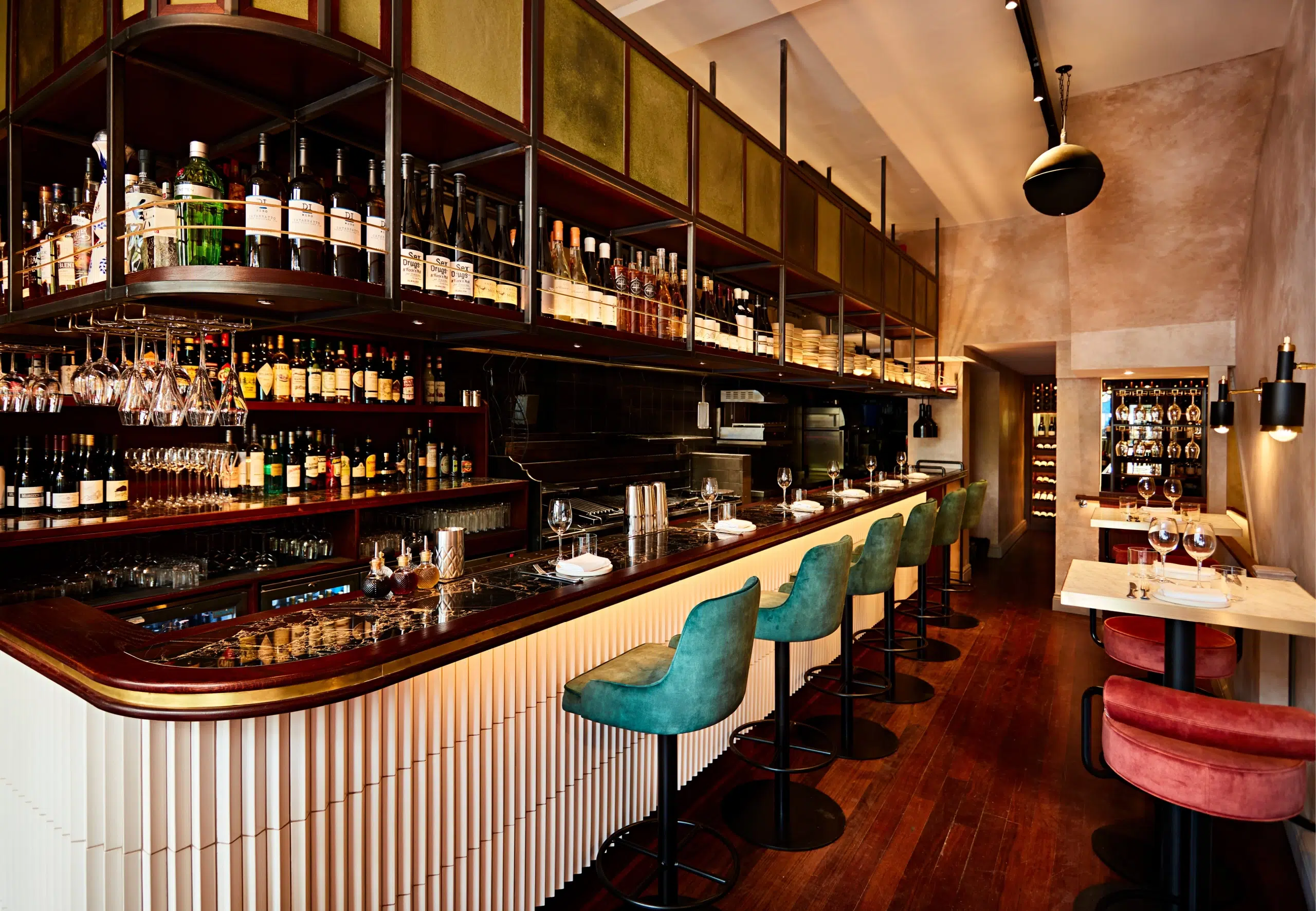 The bar at Caia with green velvet chairs
