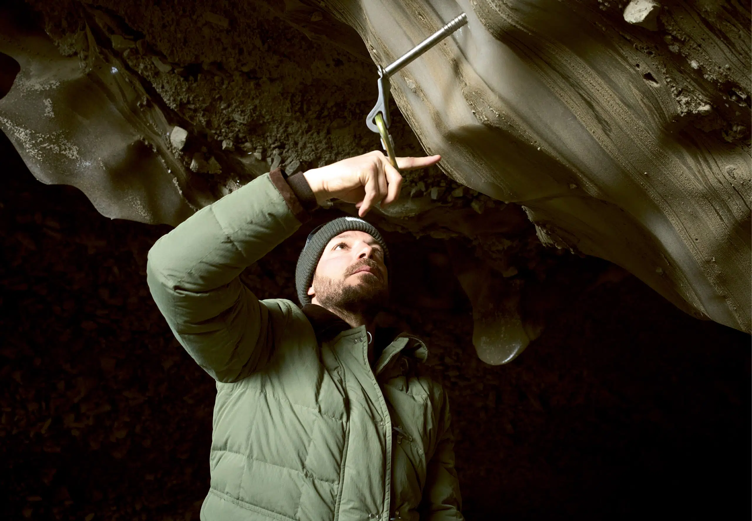 Man wearing Faye jacket in cave
